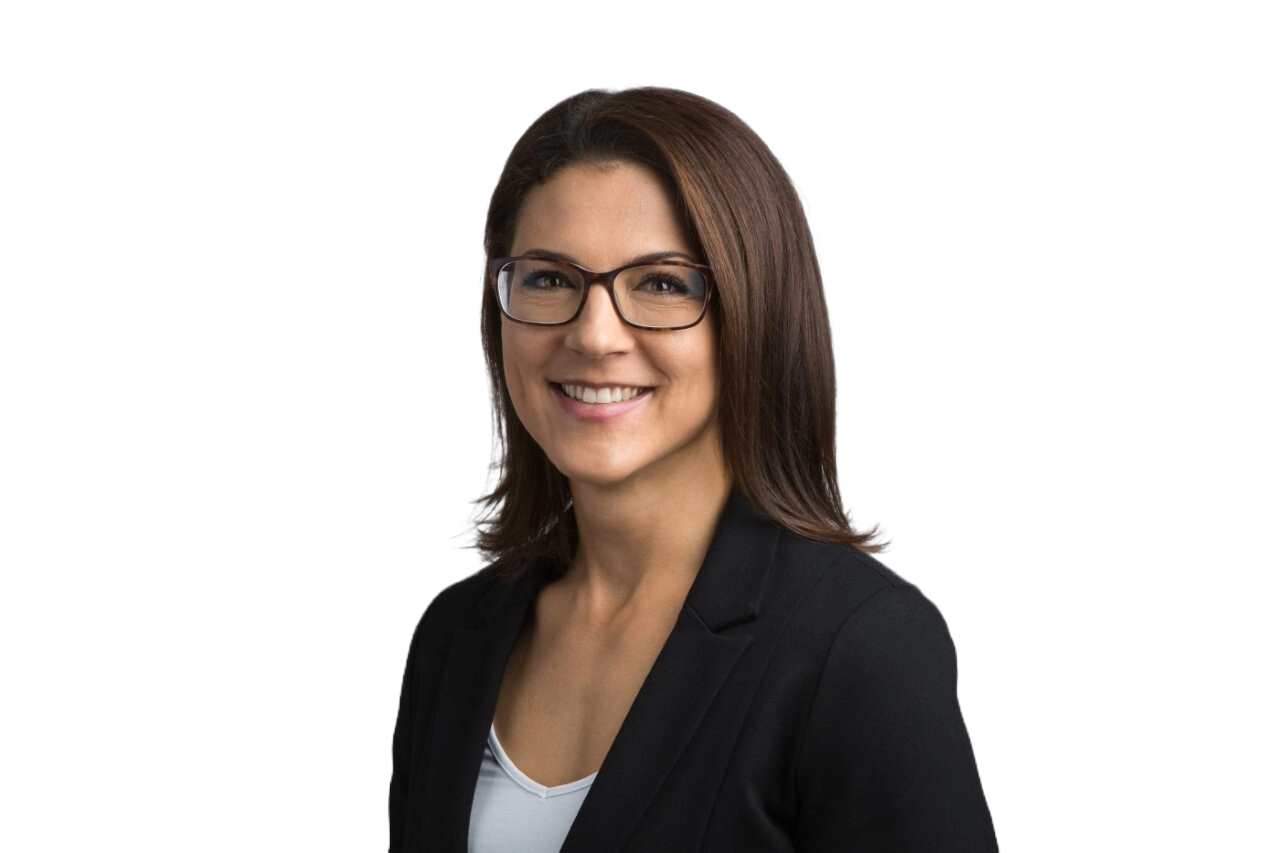 Headshot of a smiling person with brown hair and glasses, wearing a black blazer